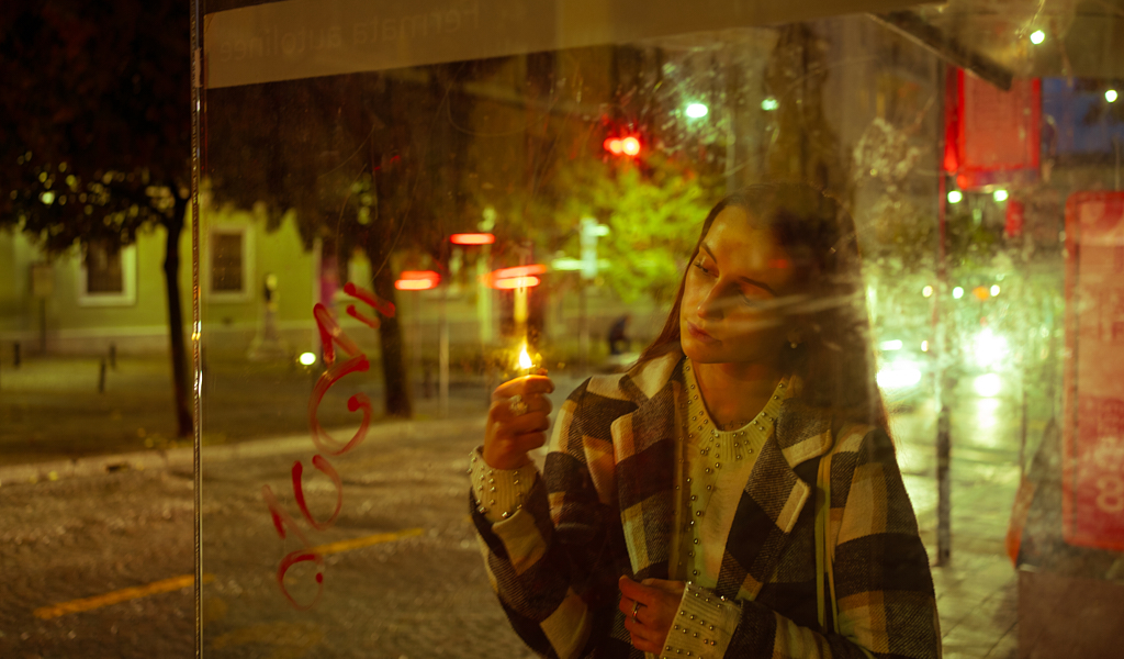 una ragazza che tiene in mano l'accendino subito dopo il tramonto